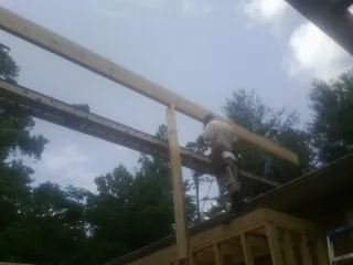 Carpenter setting a ridge beam over a new addition frame — Ice Dam Removal by Roofing Brothers in Orbisonia