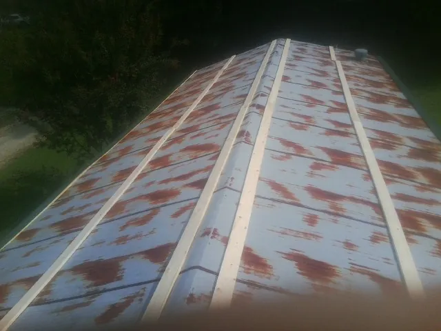Rusted metal roof panels with new wood purlins before replacement — Storm Damage Roof Repair in Orbisonia by Roofing Brothers