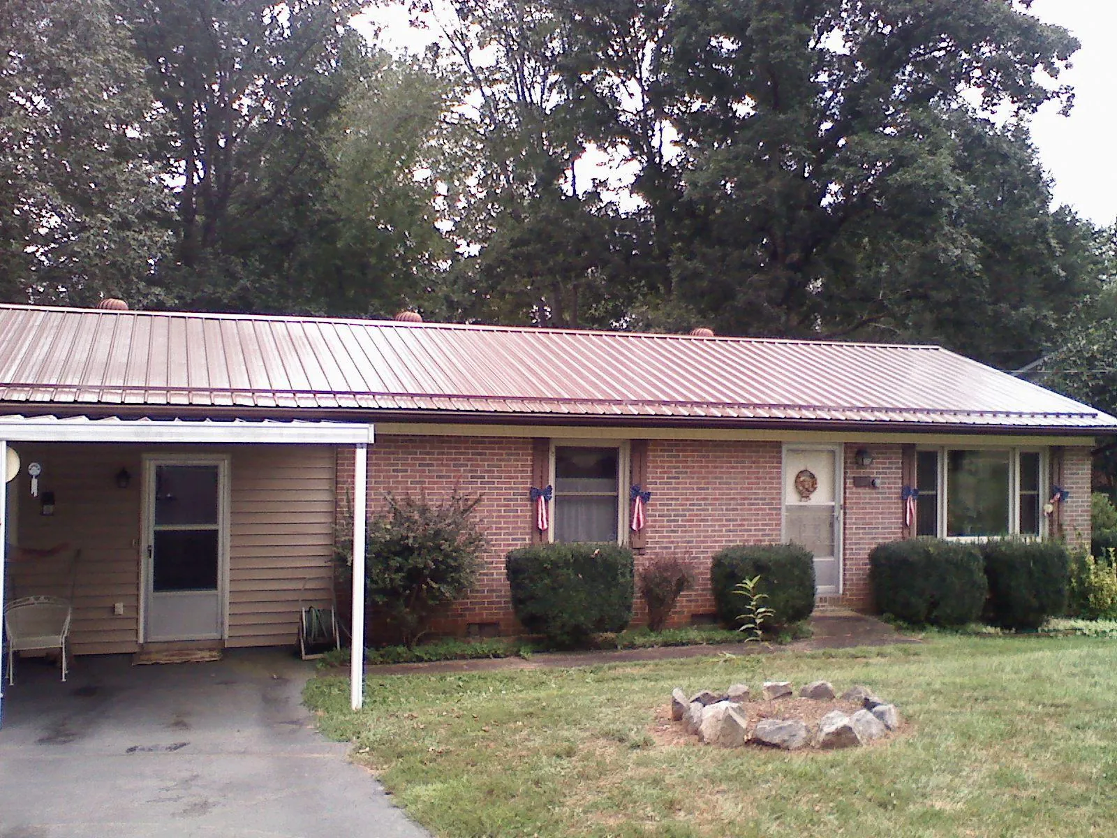 Bronze metal roof and carport on a brick ranch home — Roof Repair work by our crew in Orbisonia